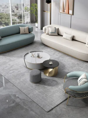 Ensemble de salon de luxe au design contemporain, comprenant deux canapés incurvés et un fauteuil assorti avec une base cannelée et des pieds en métal doré. Ameublement Hicham Marrakech.