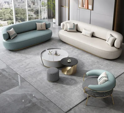 Ensemble de salon de luxe au design contemporain, comprenant deux canapés incurvés et un fauteuil assorti avec une base cannelée et des pieds en métal doré. Ameublement Hicham Marrakech.