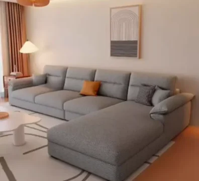 Canapé d'angle moderne avec méridienne en tissu gris texturé, parfait pour un salon contemporain. Vendu par Ameublement Hicham à Marrakech.