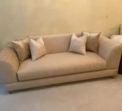 Canapé au design classique avec accoudoirs arrondis, revêtu d'un élégant tissu beige à motifs. Vendu par Ameublement Hicham à Marrakech.