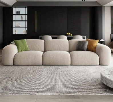 Grand canapé design contemporain aux formes organiques et arrondies, en tissu beige, pour un salon minimaliste et moderne. Vendu par Ameublement Hicham.