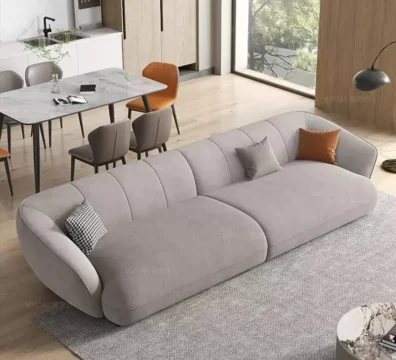 Canapé moderne au design unique avec capitonnage vertical et formes arrondies, en tissu doux gris clair, vendu par Ameublement Hicham à Marrakech.