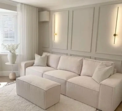 Canapé modulable de style minimaliste en tissu bouclé couleur crème, présenté avec son pouf assorti pour un salon moderne et épuré. Ameublement Hicham Marrakech.