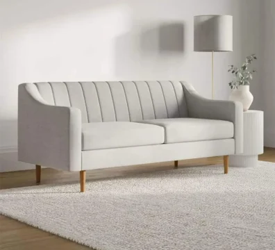 Canapé 2 places au design scandinave en tissu gris clair, caractérisé par son capitonnage vertical et ses pieds fins en bois. Ameublement Hicham Marrakech.