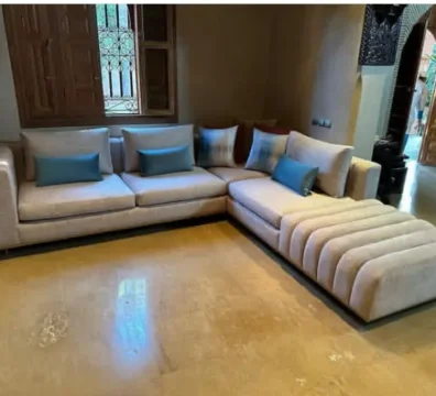 Canapé d'angle de style design avec une méridienne au capitonnage original, en tissu beige texturé. Vente chez Ameublement Hicham à Marrakech.