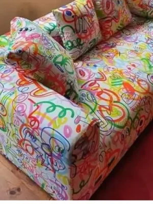 Canapé au design audacieux et original avec un revêtement en tissu à motifs graffiti multicolores, pour une pièce de caractère. Ameublement Hicham Marrakech.