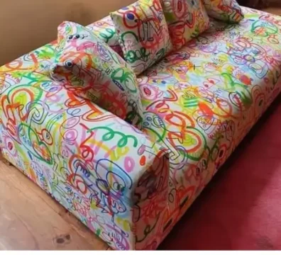 Canapé au design audacieux et original avec un revêtement en tissu à motifs graffiti multicolores, pour une pièce de caractère. Ameublement Hicham Marrakech.