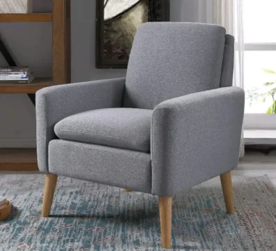 Fauteuil confortable de style scandinave en tissu gris chiné avec des pieds en bois clair, idéal pour un coin lecture. Ameublement Hicham Marrakech.
