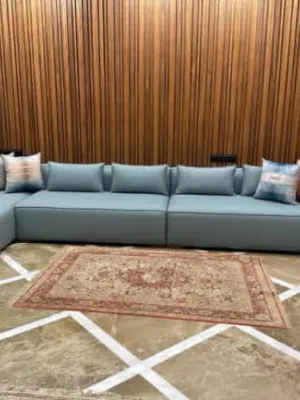 Grand canapé d'angle modulable de style moderne et épuré, en tissu bleu ciel, dans un intérieur contemporain. Disponible chez Ameublement Hicham à Marrakech.