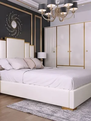 Lit au design Art Déco avec une tête de lit géométrique étagée, en tissu blanc avec des accents dorés, assorti à l'armoire. Ameublement Hicham Marrakech.