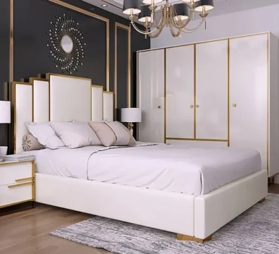 Lit au design Art Déco avec une tête de lit géométrique étagée, en tissu blanc avec des accents dorés, assorti à l'armoire. Ameublement Hicham Marrakech.