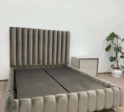 Structure de lit au design unique avec un capitonnage tubulaire sur la tête de lit et le cadre, en velours gris. Ameublement Hicham Marrakech.