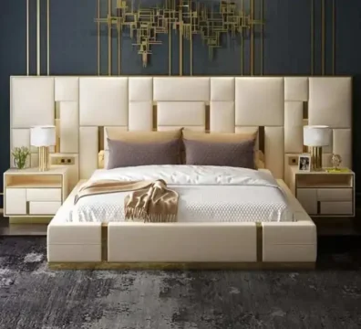 Ensemble de lit de luxe avec une tête de lit murale géométrique blanche et dorée, un cadre de lit assorti et des chevets intégrés. Ameublement Hicham Marrakech.