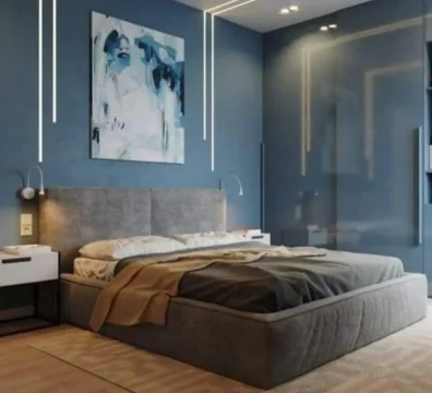 Lit double au design moderne et minimaliste avec cadre et tête de lit en tissu gris, dans une chambre contemporaine. Ameublement Hicham Marrakech.