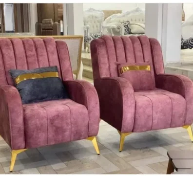 Paire de fauteuils design de style Art Déco en velours rose ancien, avec capitonnage vertical et pieds en métal doré. Ameublement Hicham Marrakech.