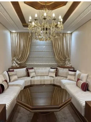 Luxueux salon marocain en U avec sedari en tissu blanc et bordeaux, et une table en verre octogonale, dans un décor élégant. Ameublement Hicham Marrakech.
