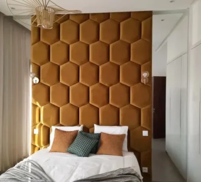 Spectaculaire tête de lit murale faite de panneaux hexagonaux capitonnés en velours jaune moutarde, pour une chambre design. Ameublement Hicham Marrakech.